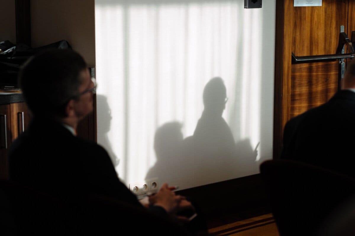 Shadows of silhouettes of people sitting in the hall