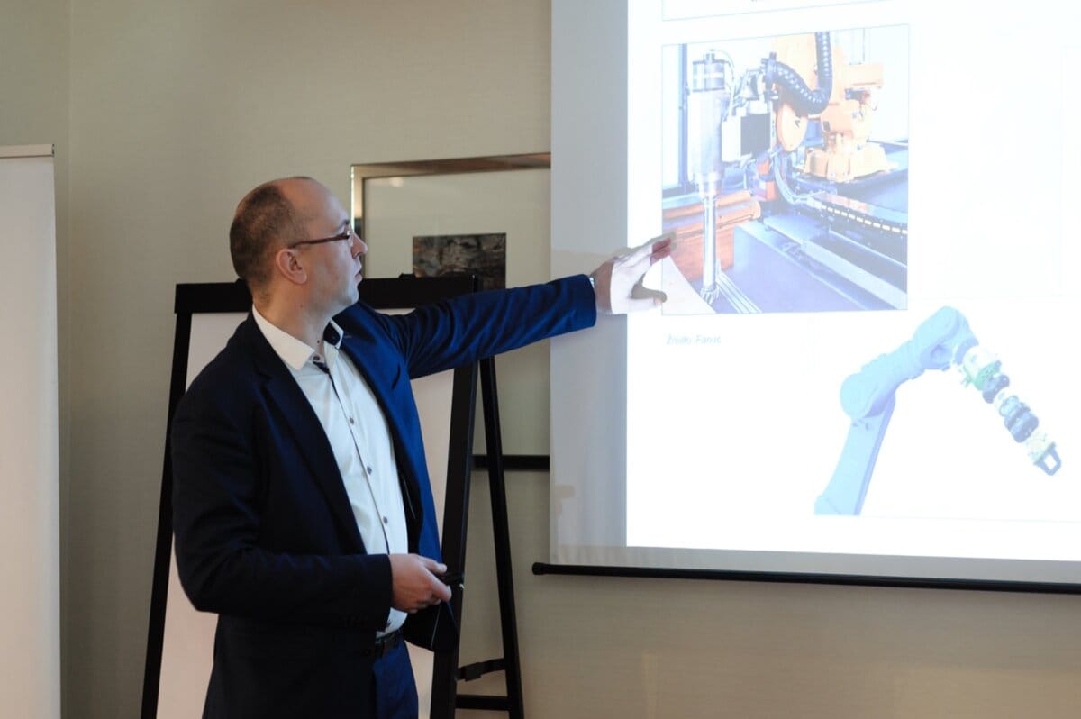 A man showing a presentation showing the work of industrial robots