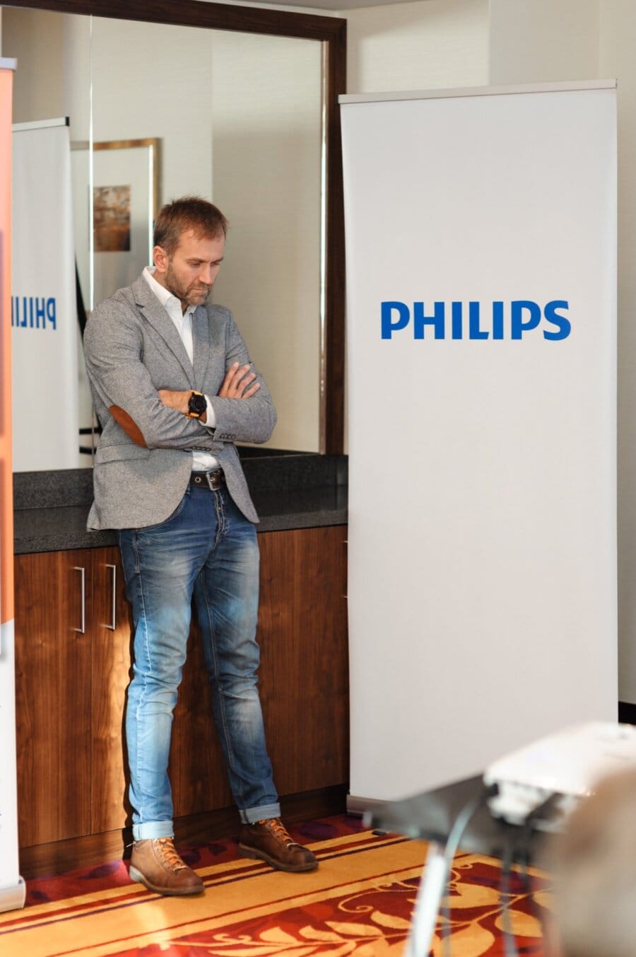 A thoughtful man next to a roll-up with the Philips logo