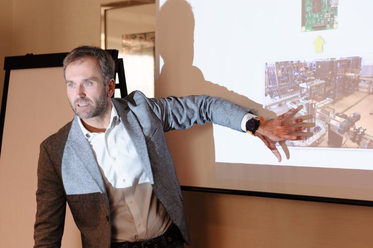 Man speaks emotionally while showing production hall at presentation  