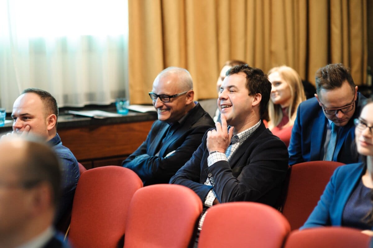 Two cheerful men sitting at a conference