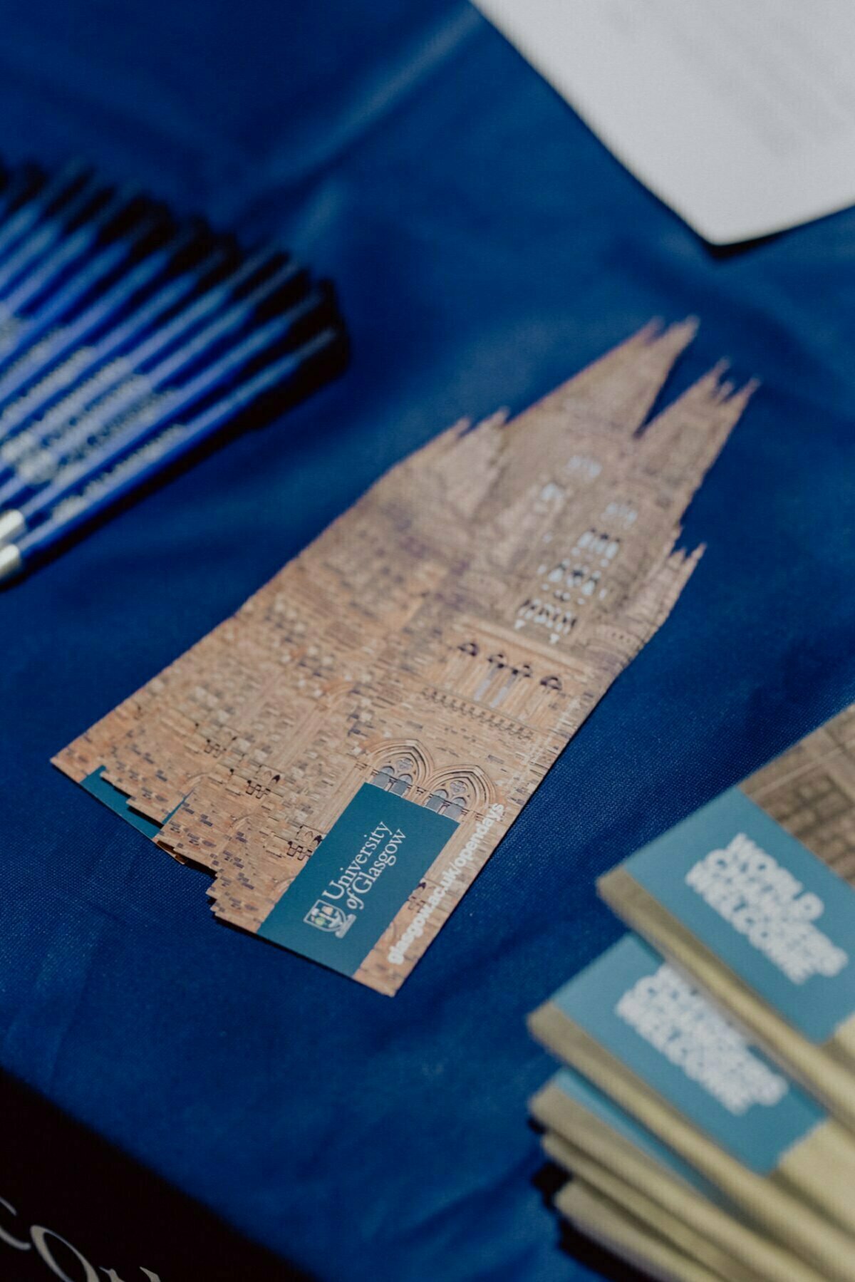 Close-up of a table with neatly stacked tabs with an architectural design and the words "Christ Church". On the left are several blue pens, on the right are partially visible stacks of other prints, perfectly capturing the event photo by event photographer warsaw. 