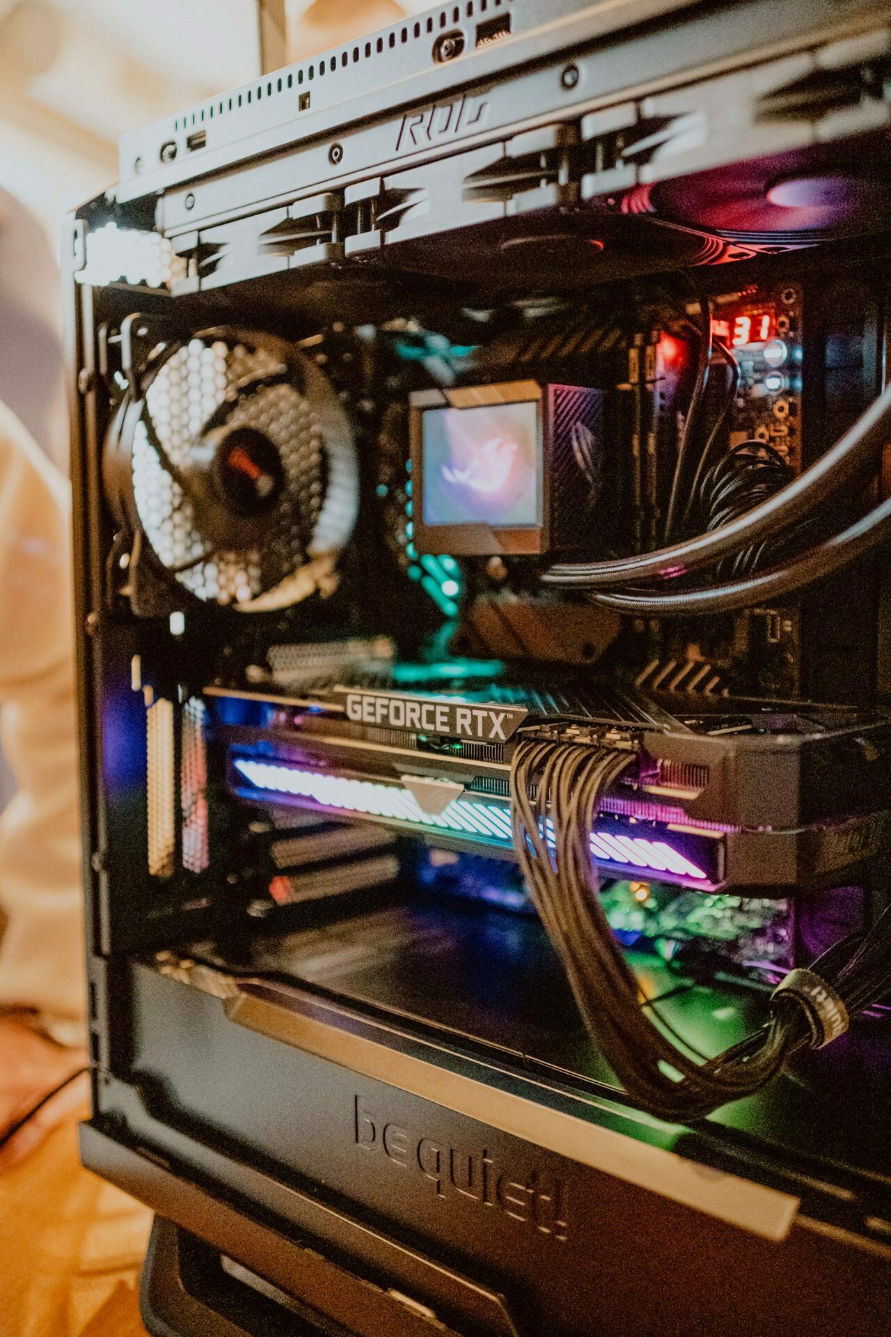 The attraction is a desktop tower with an open side panel showing off the internal components, almost like a press briefing. Visible are the large cooling fan, GeForce RTX graphics card, colorful RGB lighting and tidy cabling. The case is marked with "be Quiet!" on the front.