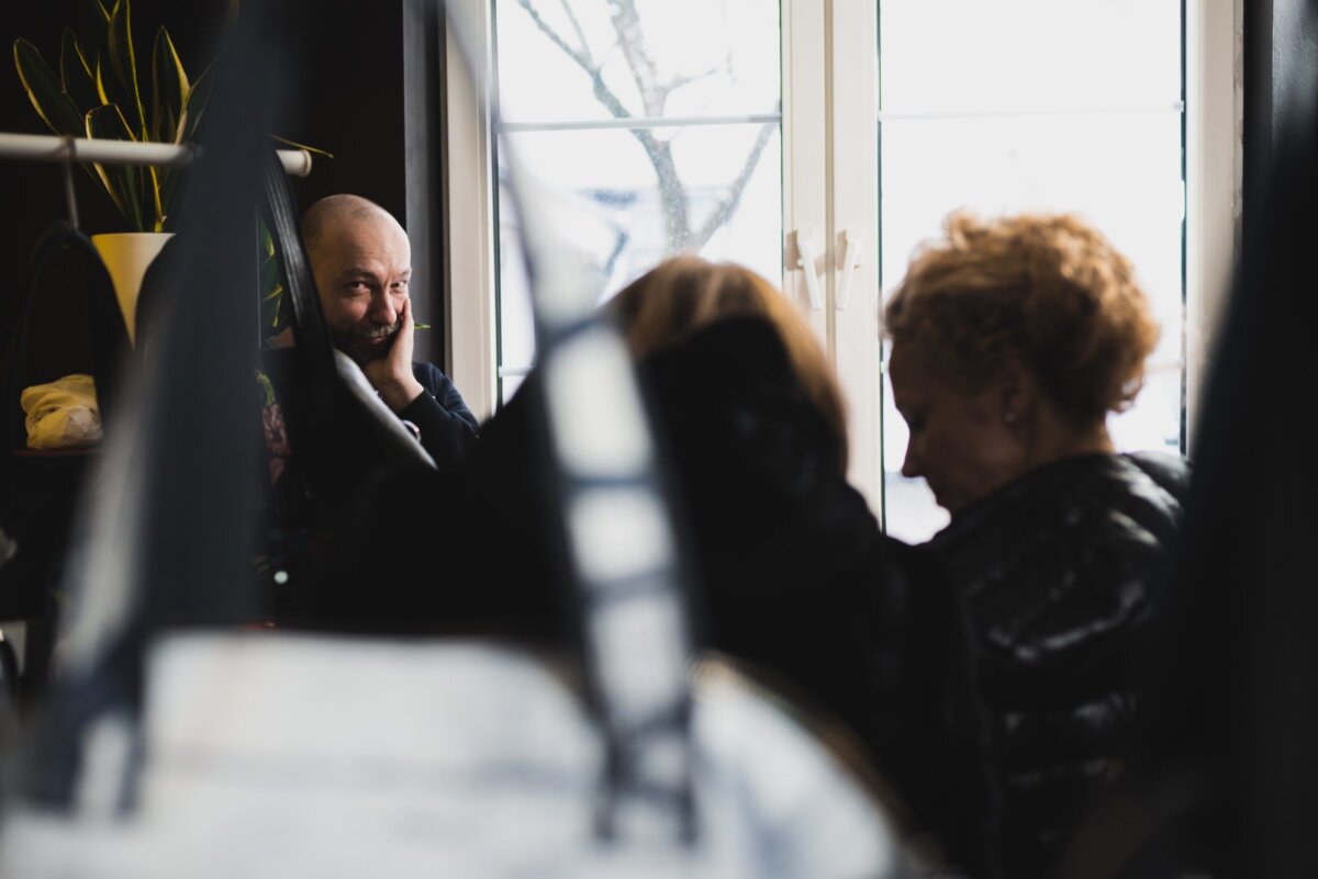 Bald man peeks between bags