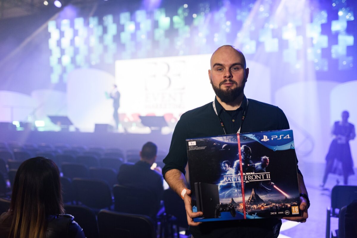 Man holding Playstation 4 console he got as a reward