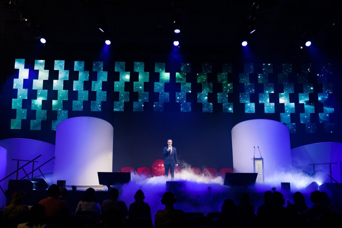 Presenter on a stage covered in heavy smoke