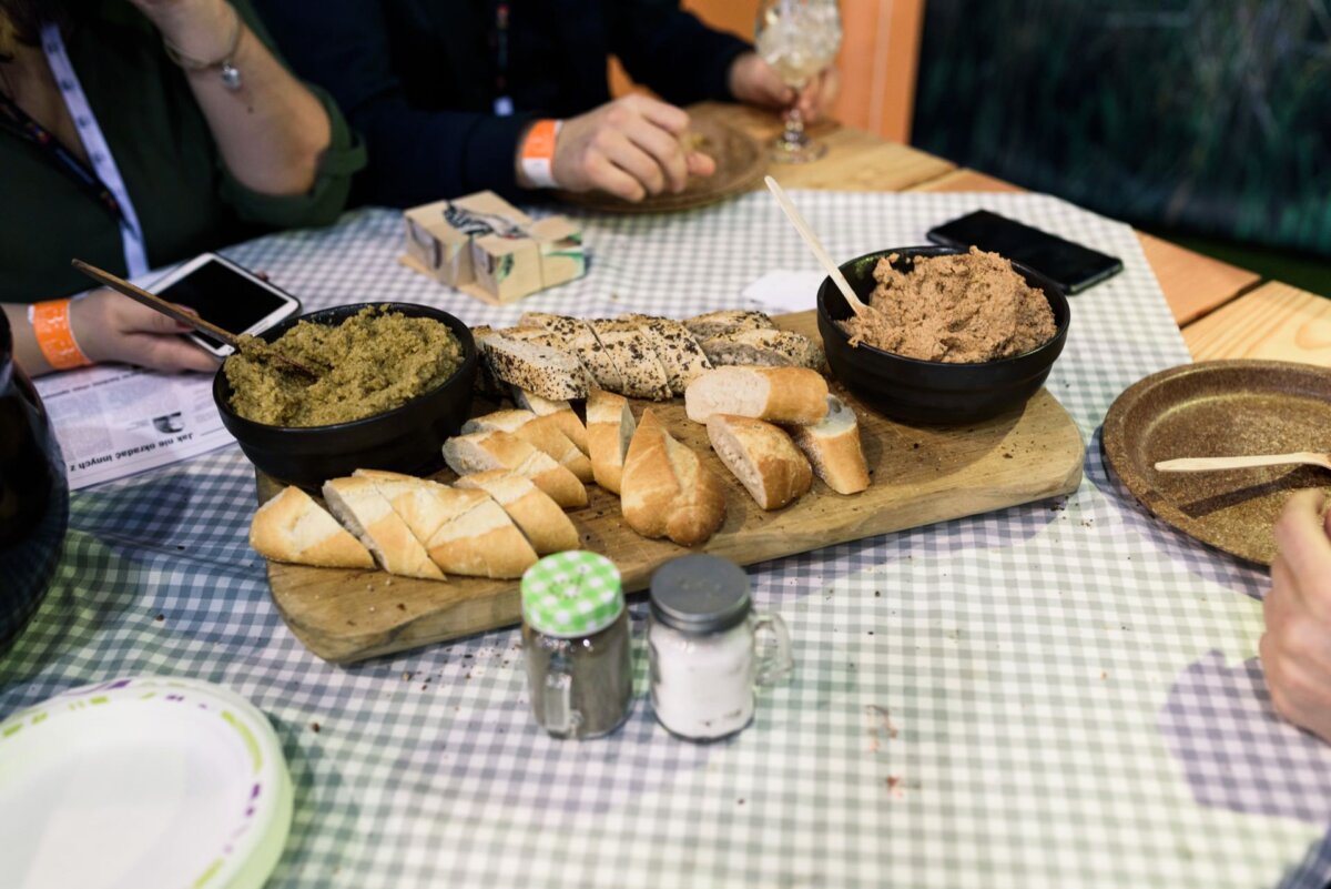 A table with bread and bowls of some kind of paste