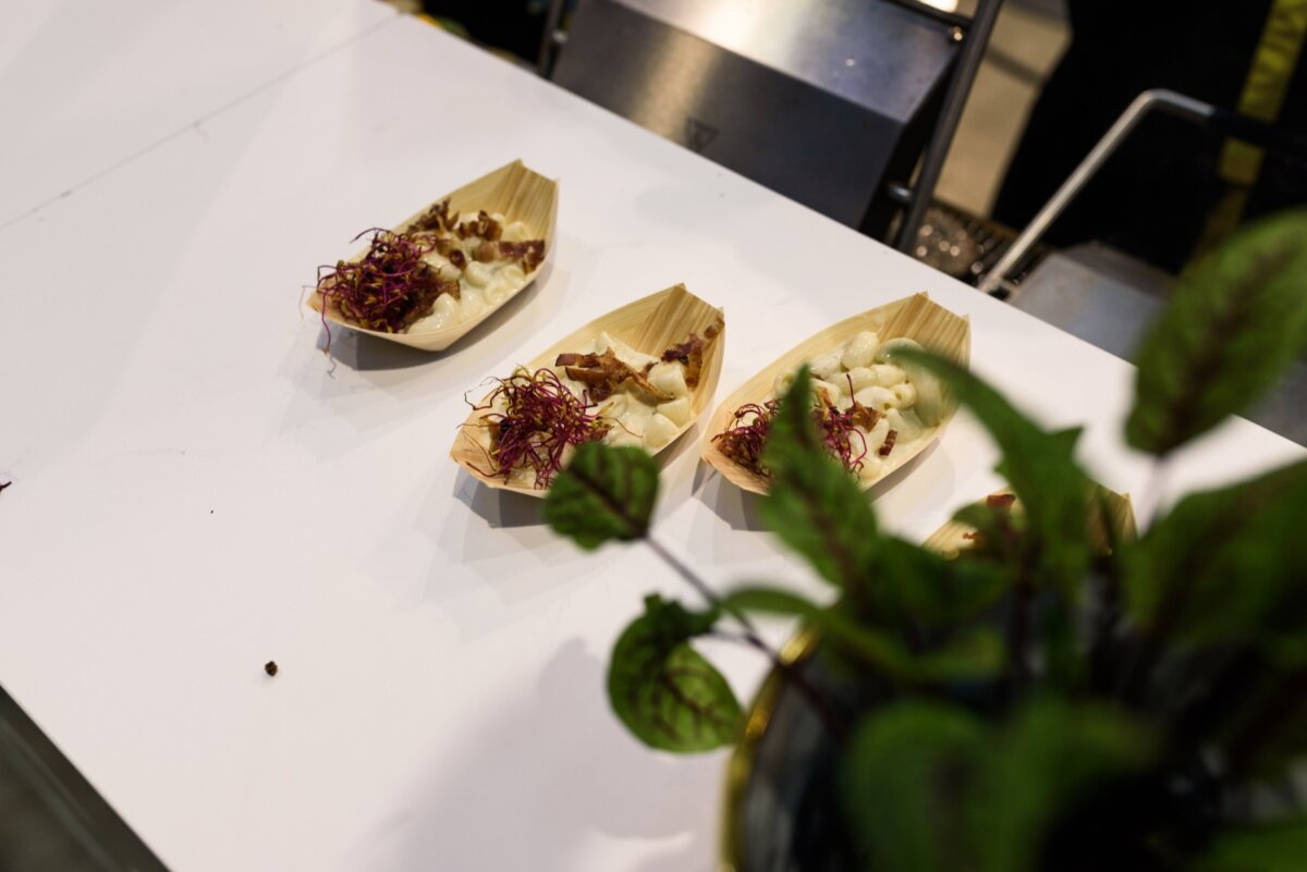 Small snacks in the shape of a boat on a white table with a green flower