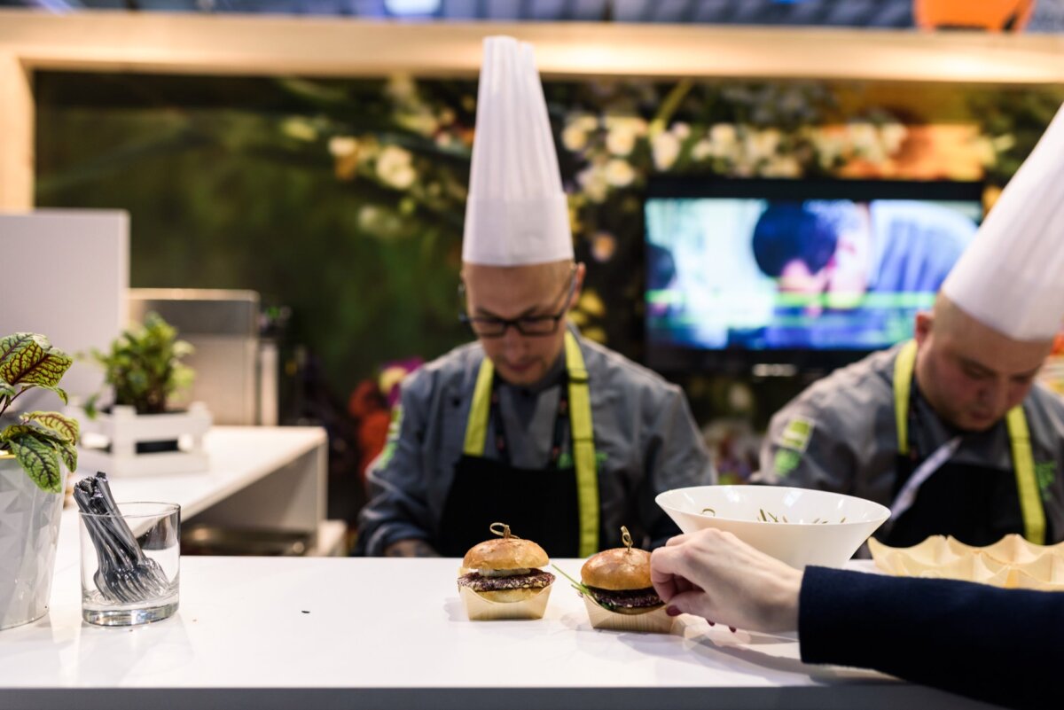 Cook in white ruddy hat makes mini burgers