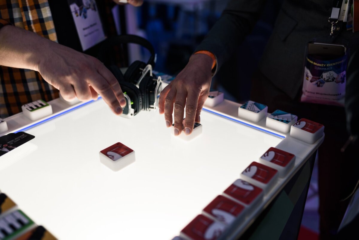 Hands holding blocks on a white-lit table