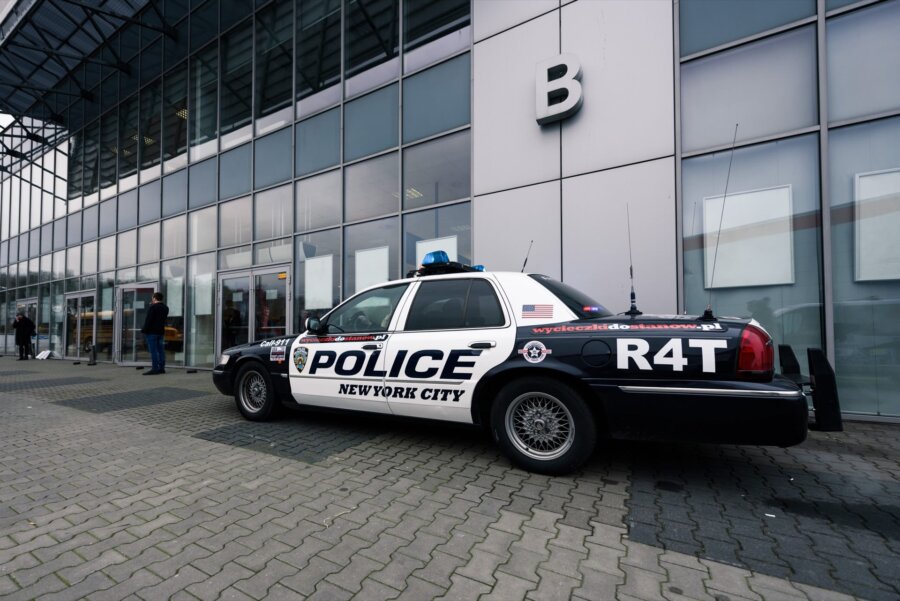 American police car in front of the entrance to the market hall with the letter B on the building