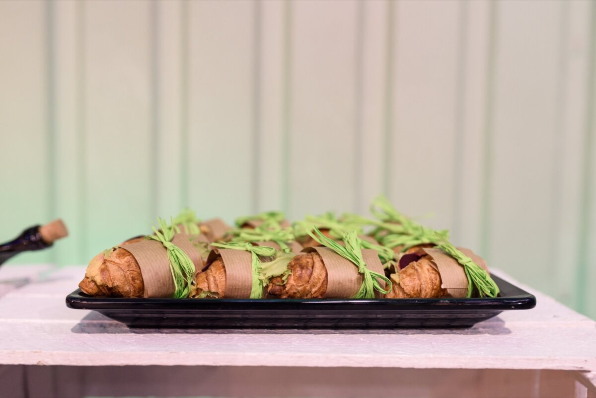 A plate of croissants wrapped in paper and green ribbon