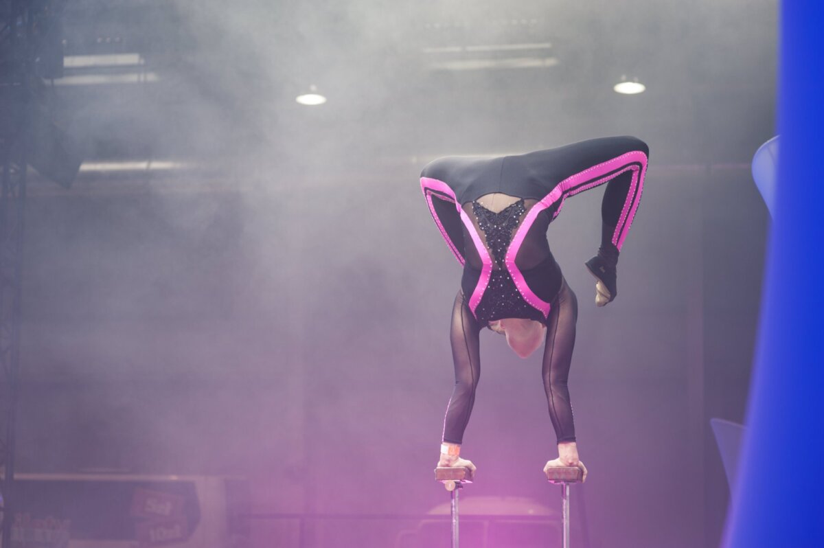 Woman standing on hands supported by two metal bars