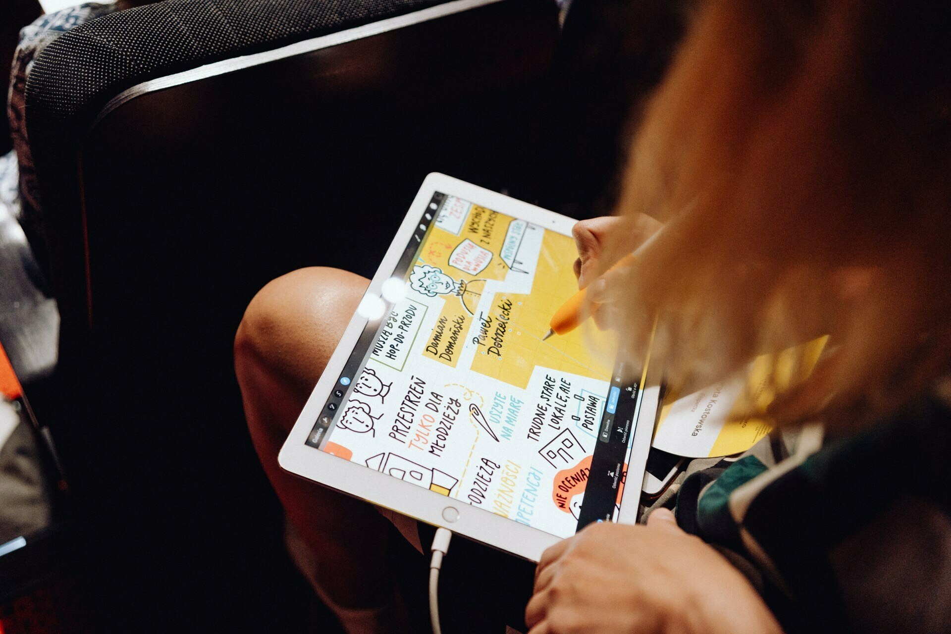 A person uses a tablet with a stylus to take colorful, illustrated notes. The notes include drawings, text and highlighted sections. The scene resembles an academic or creative setting, just as a photographer at an event can capture the energy of the event using digital methods of event photojournalism.  