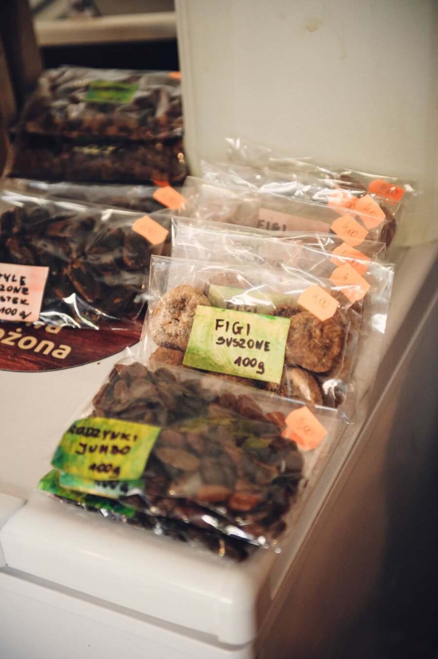 Na targach kulinarnych na ladzie wywieszone są różne opakowania suszonych owoców z napisami w języku polskim. W plastikowych torebkach znajdują się np. figi suszone i inne suszone owoce, a na każdym opakowaniu znajdują się pomarańczowe naklejki z cenami.