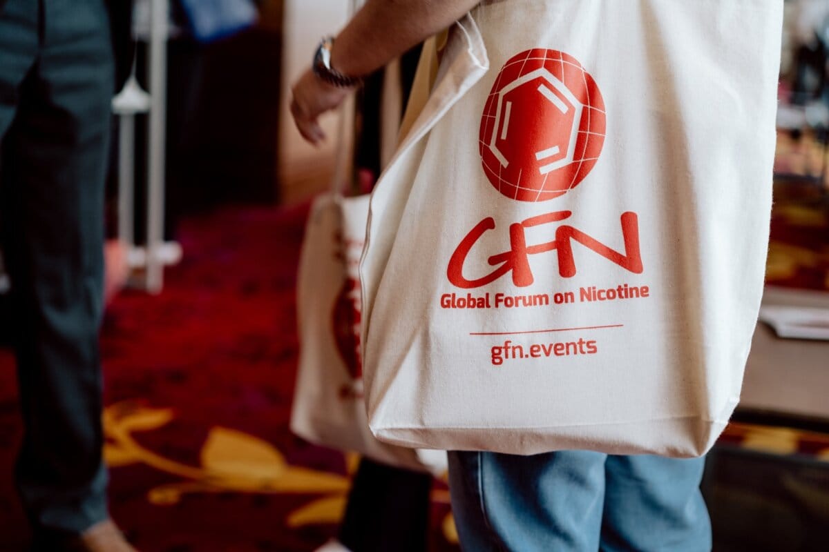 Two people holding white bags with red logos and the text "GFN Global Forum on Nicotine" and "gfn.events," captured in a photo essay from the conference.