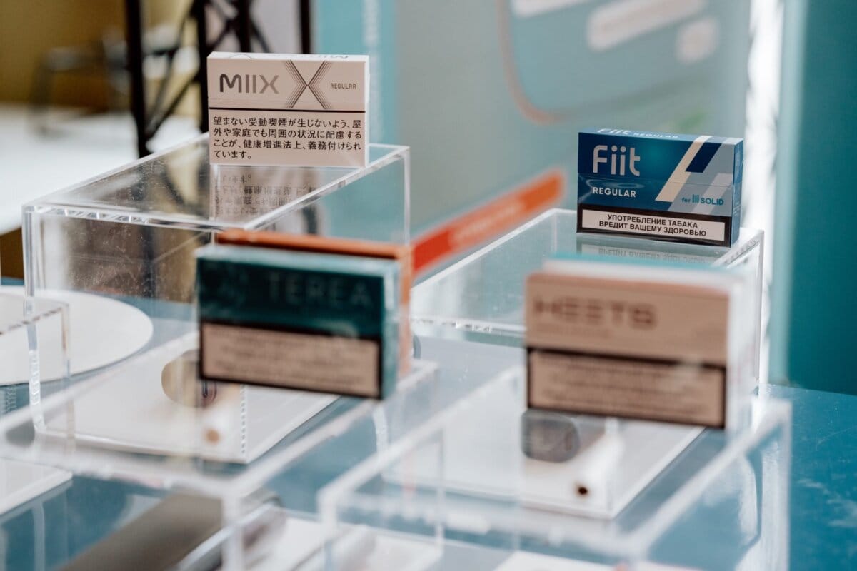 A display of various cigarette packs, each housed in clear acrylic boxes. The brands visible are MIIX, TEREA, Fiit and MEVIUS. The overall setup is sleek and modern, with an emphasis on product presentation, reminiscent of a photo essay of an event.  