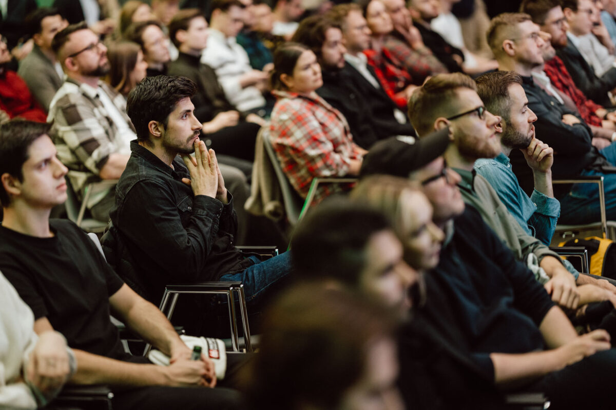 zdjecia eventowe aula polska bnp paribas warszawa 030 Zróżnicowana grupa ludzi siedzi blisko siebie w rzędach, uważnie słuchając i oglądając coś przed sobą na czymś, co wydaje się być konferencją lub seminarium.