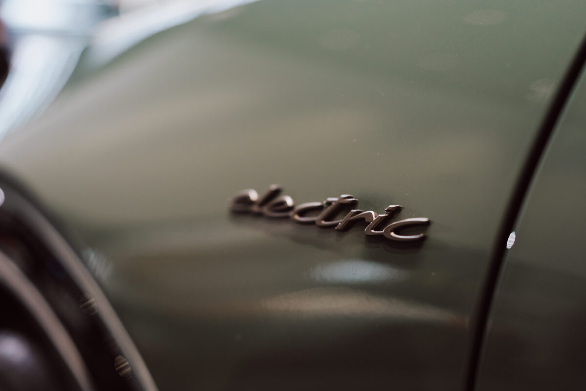 Eine Nahaufnahme des Wagens in Metallic-Grün mit einer verchromten 'Electric'-Plakette an der Seite fängt die Aufregung bei der Eröffnung des Showrooms perfekt ein.