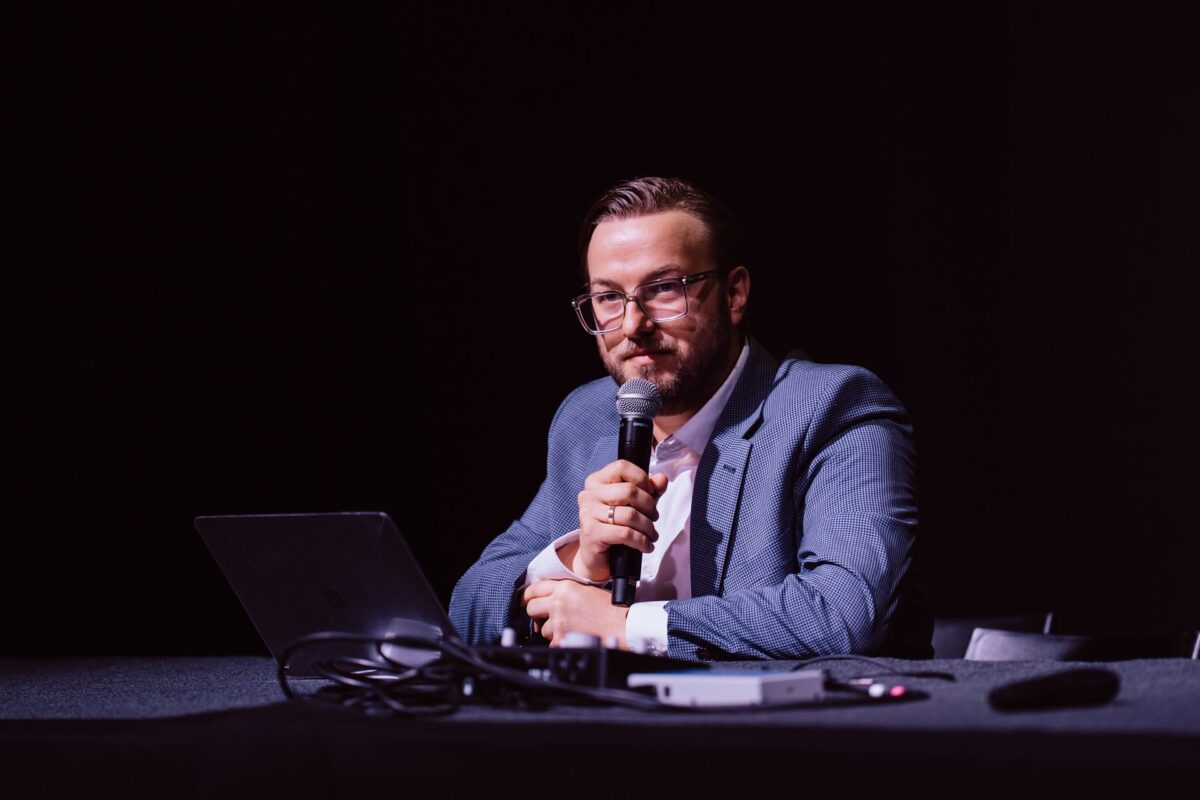 Prelegent przy laptopie podczas prezentacji na AES Europe 2025