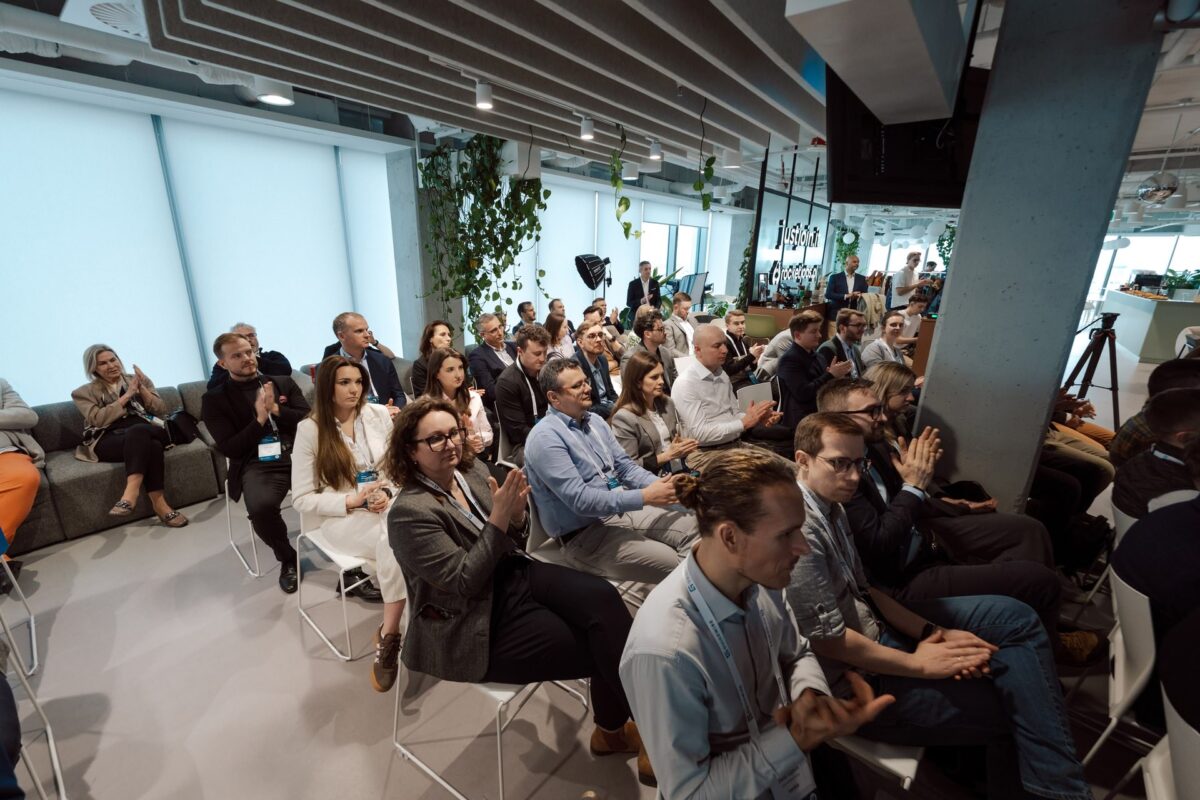 Publiczność bije brawo podczas Guidewire Warsaw Pricing Meetup 2026, w tle kamera produkcyjna