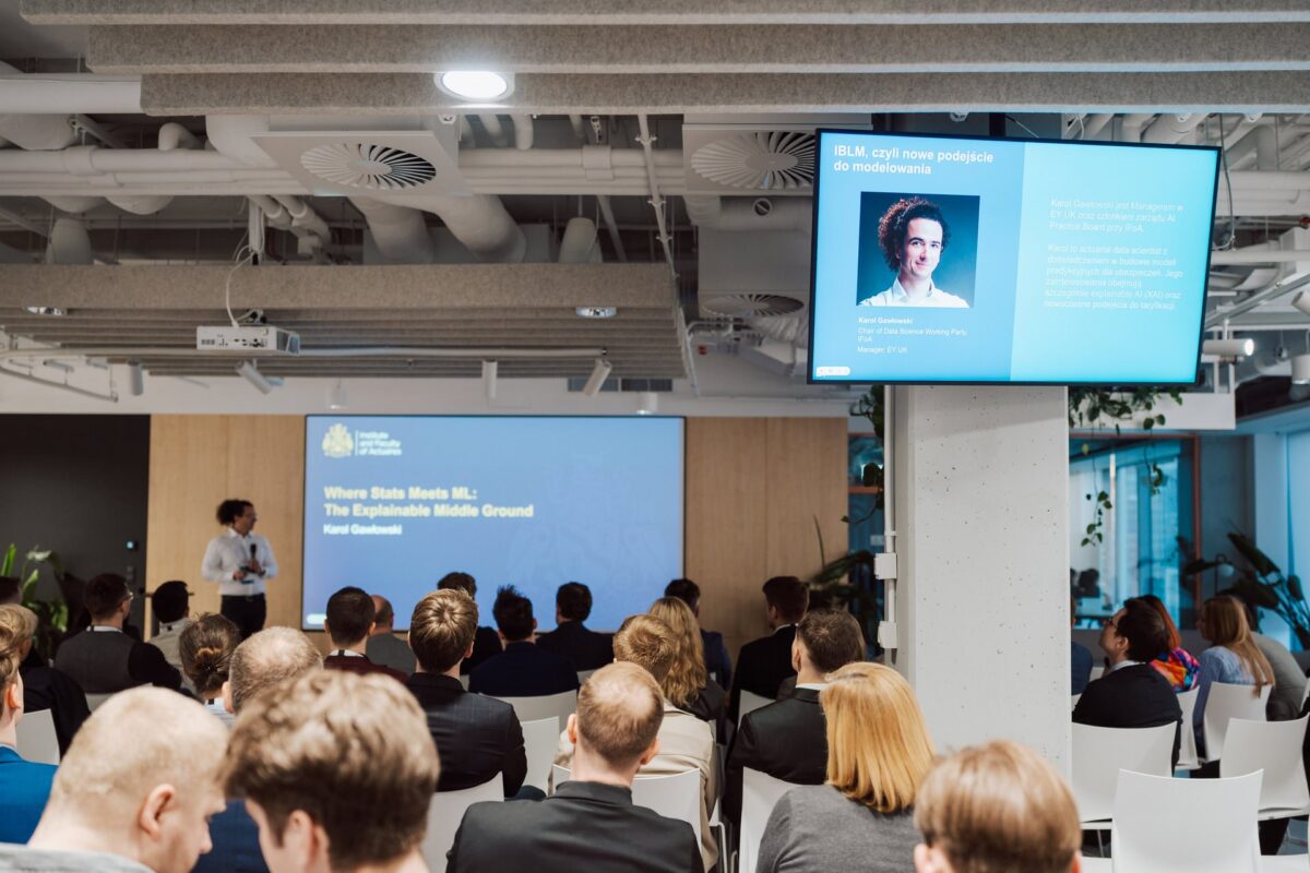 Zapowiedź prelegenta na ekranach podczas Guidewire Warsaw Pricing Meetup 2026