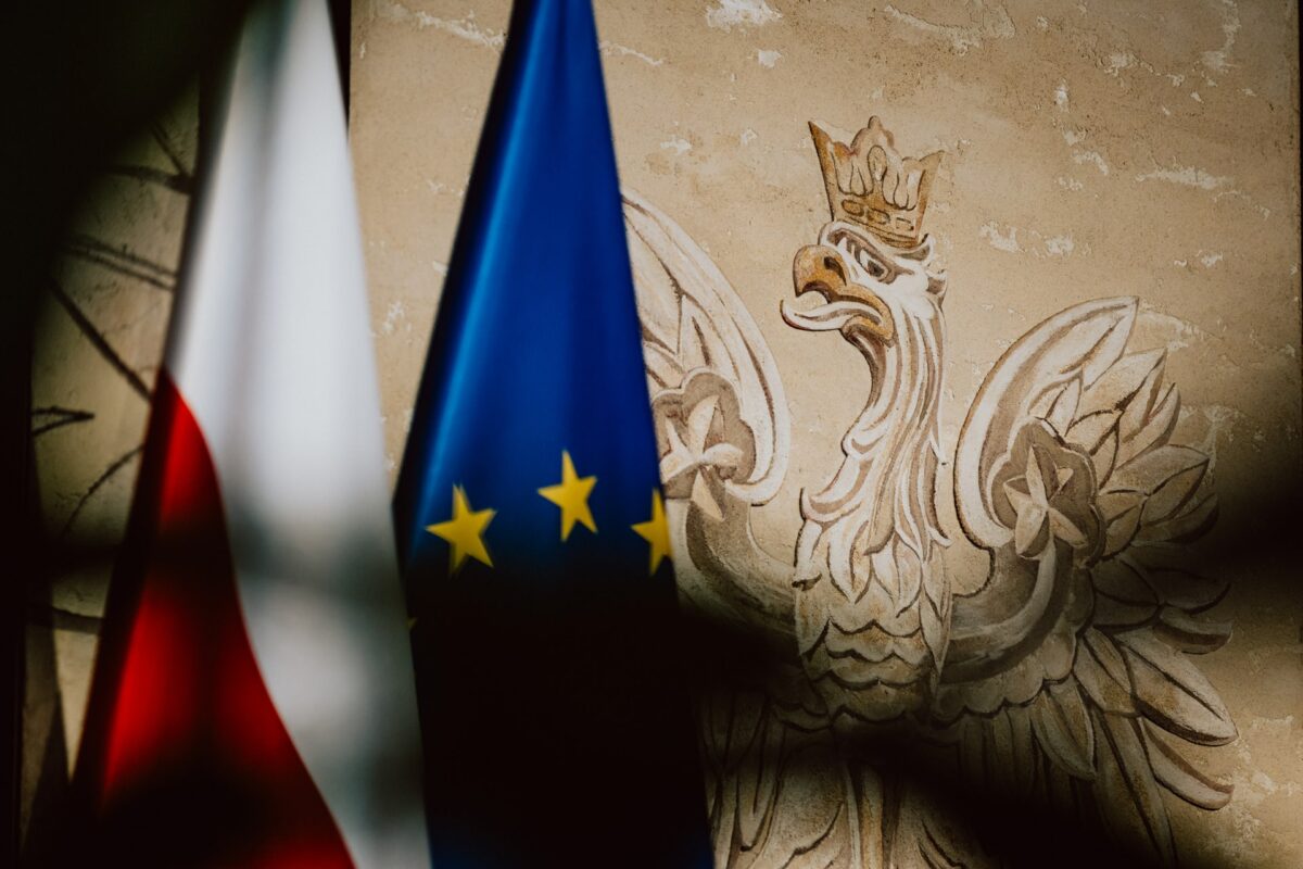 Godło i flagi przy wejściu na konferencję Rządowego Centrum Legislacji