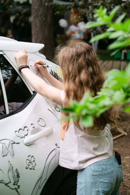Dziecko rysuje markerem na białym Lexusie w strefie marki na Lazy Sunday
