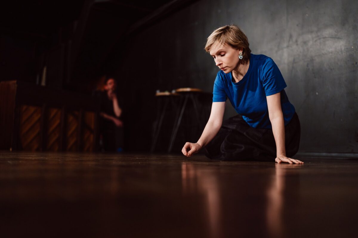 Komiczka na scenie Klubu Komediowego, odbicie w podłodze sceny