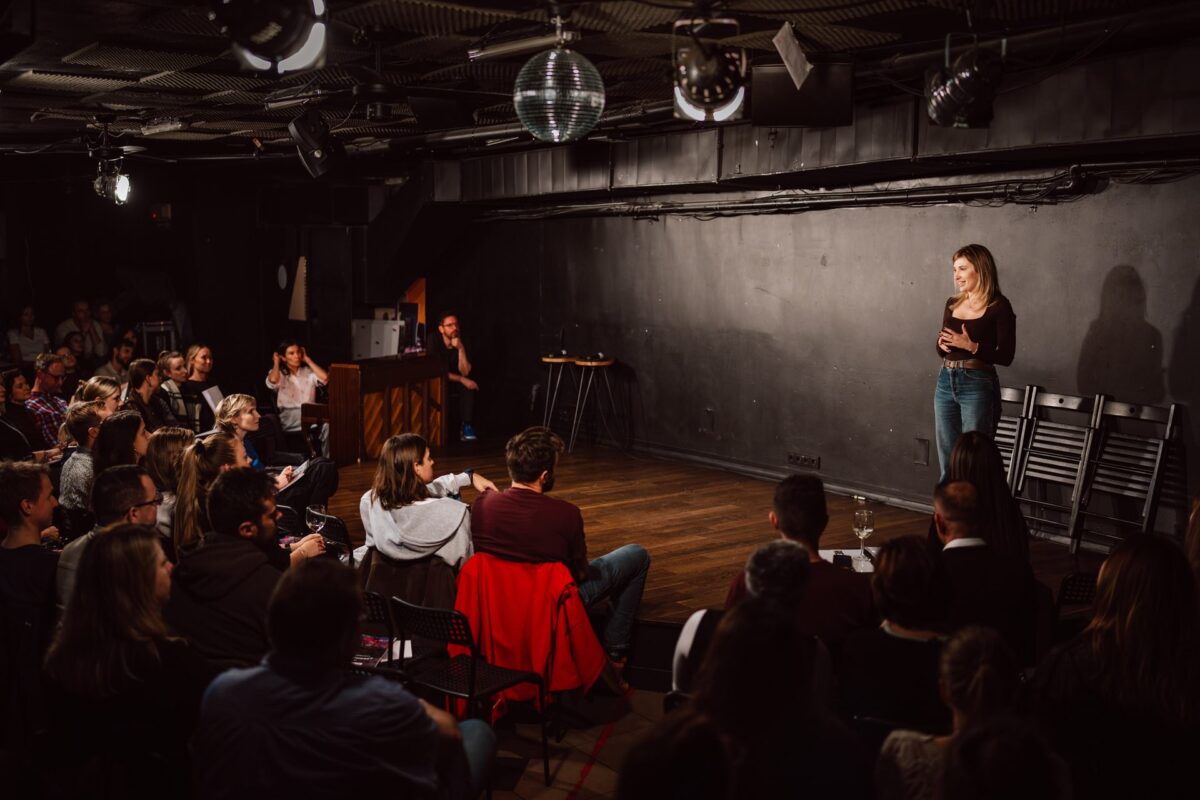 Komiczka na scenie Klubu Komediowego podczas spektaklu impro dla JustJoin.it