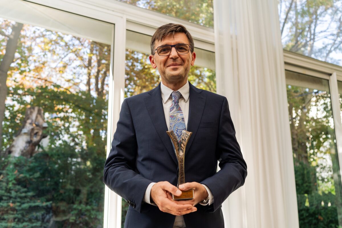 Laureat ze statuetką Lider Szczepień, portret przy oknie