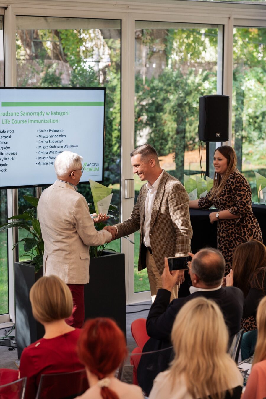 Prowadzący gratuluje laureatowi nagrody podczas gali Vaccine Forum 2023