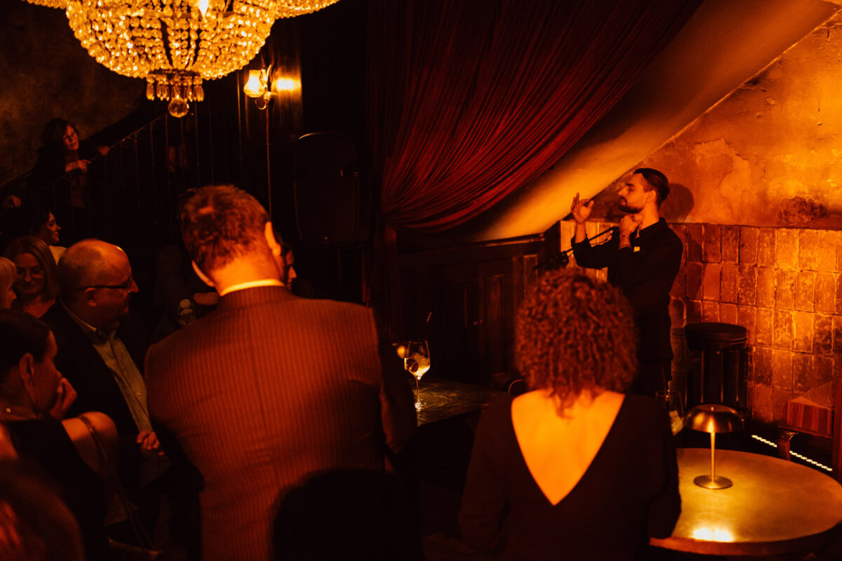 An illusionist's show in a spotlight under a chandelier in Weles Bar