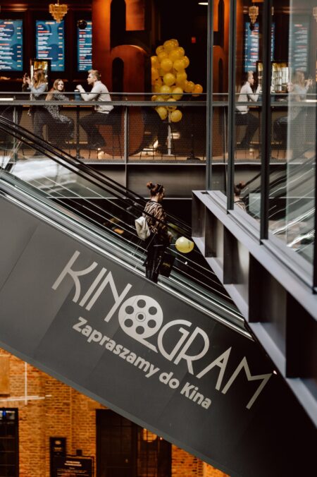 Widok z góry na schody ruchome i neon KinoGram podczas eventu Batwheels