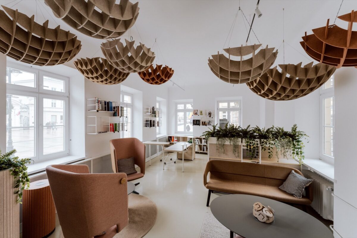 Narbutas lounge area with an armchair and sofa by the tall showroom windows