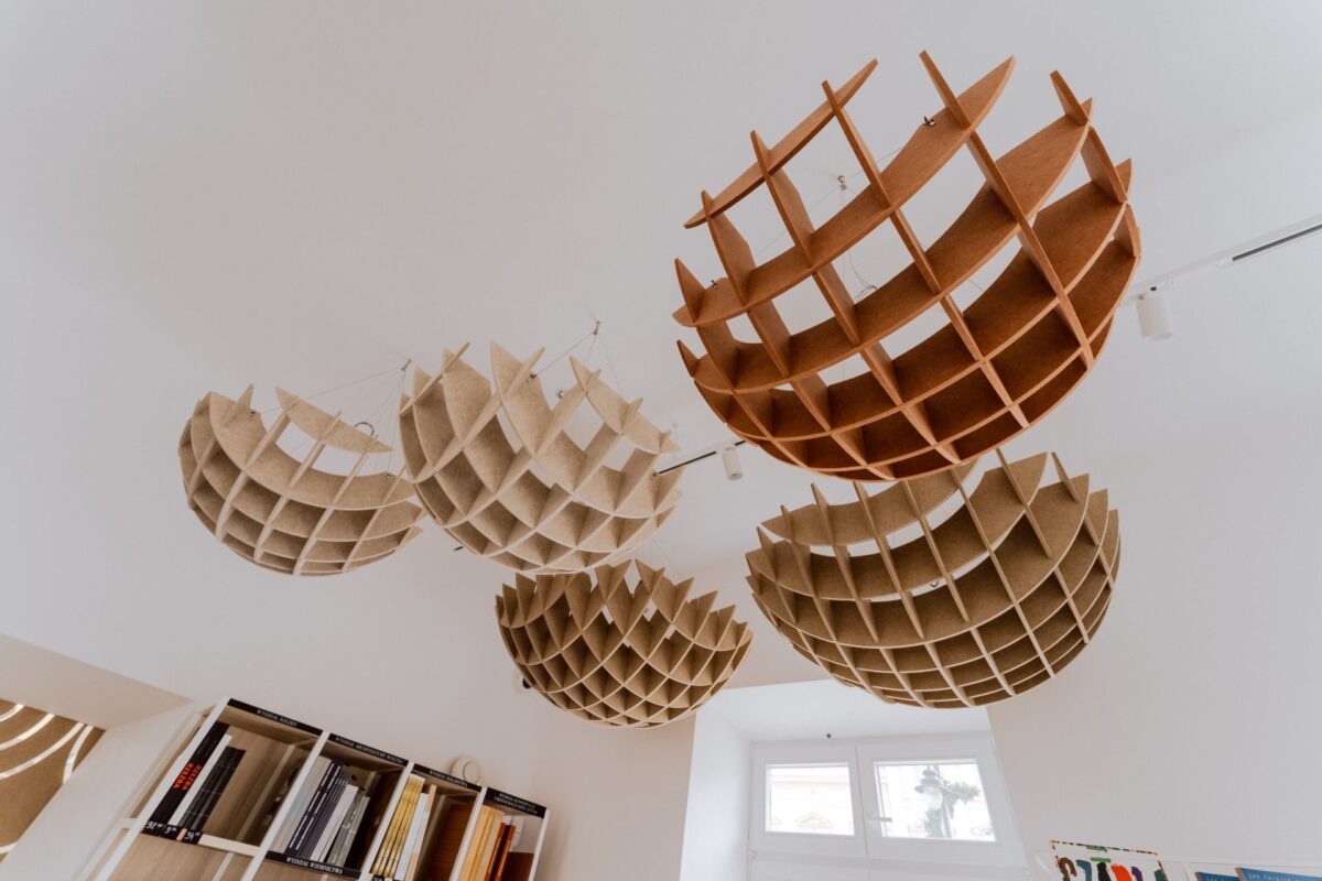 Openwork cardboard shades suspended from the showroom ceiling at Narbutas