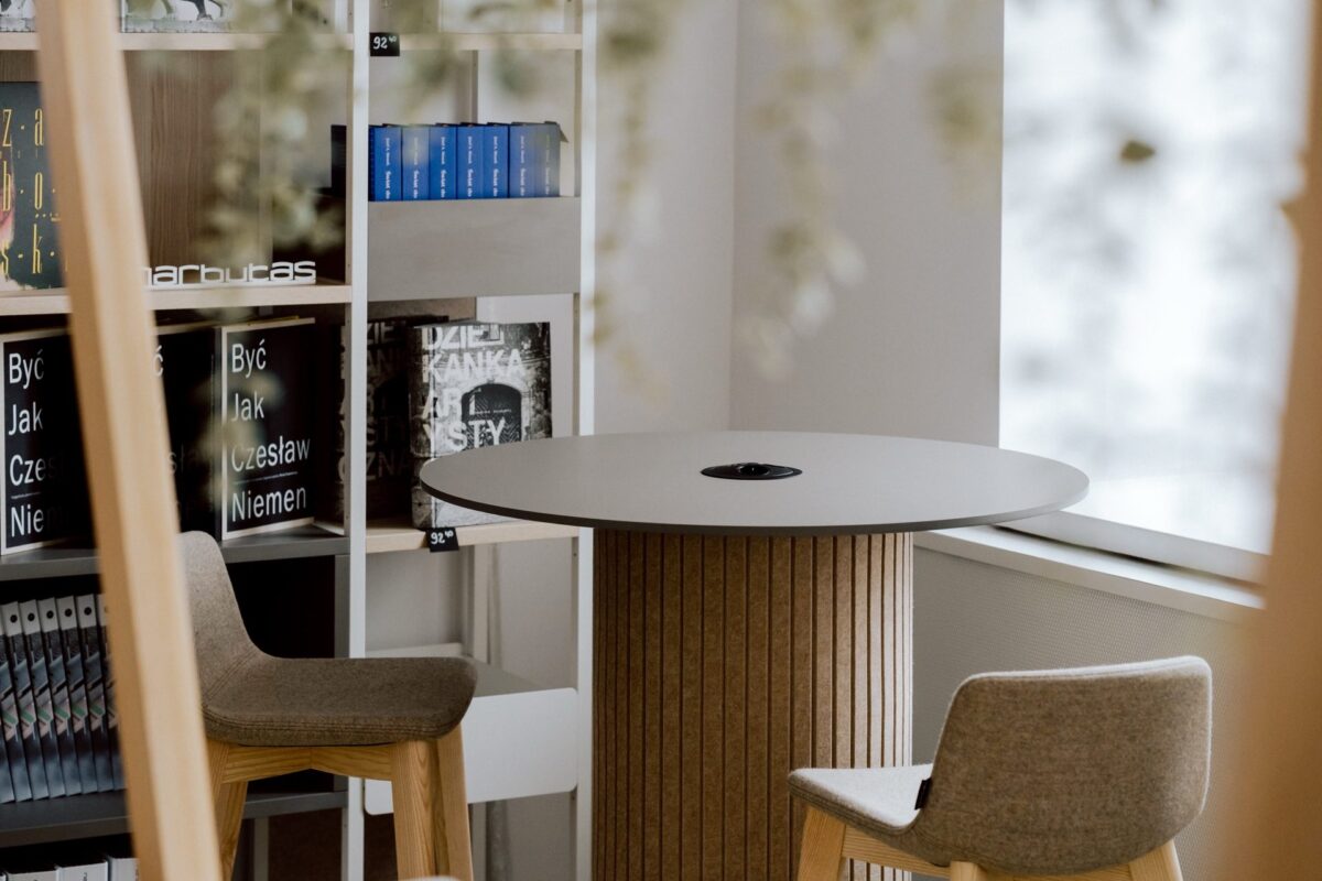 Table with bar chairs by a shelving unit with the Narbutas logo