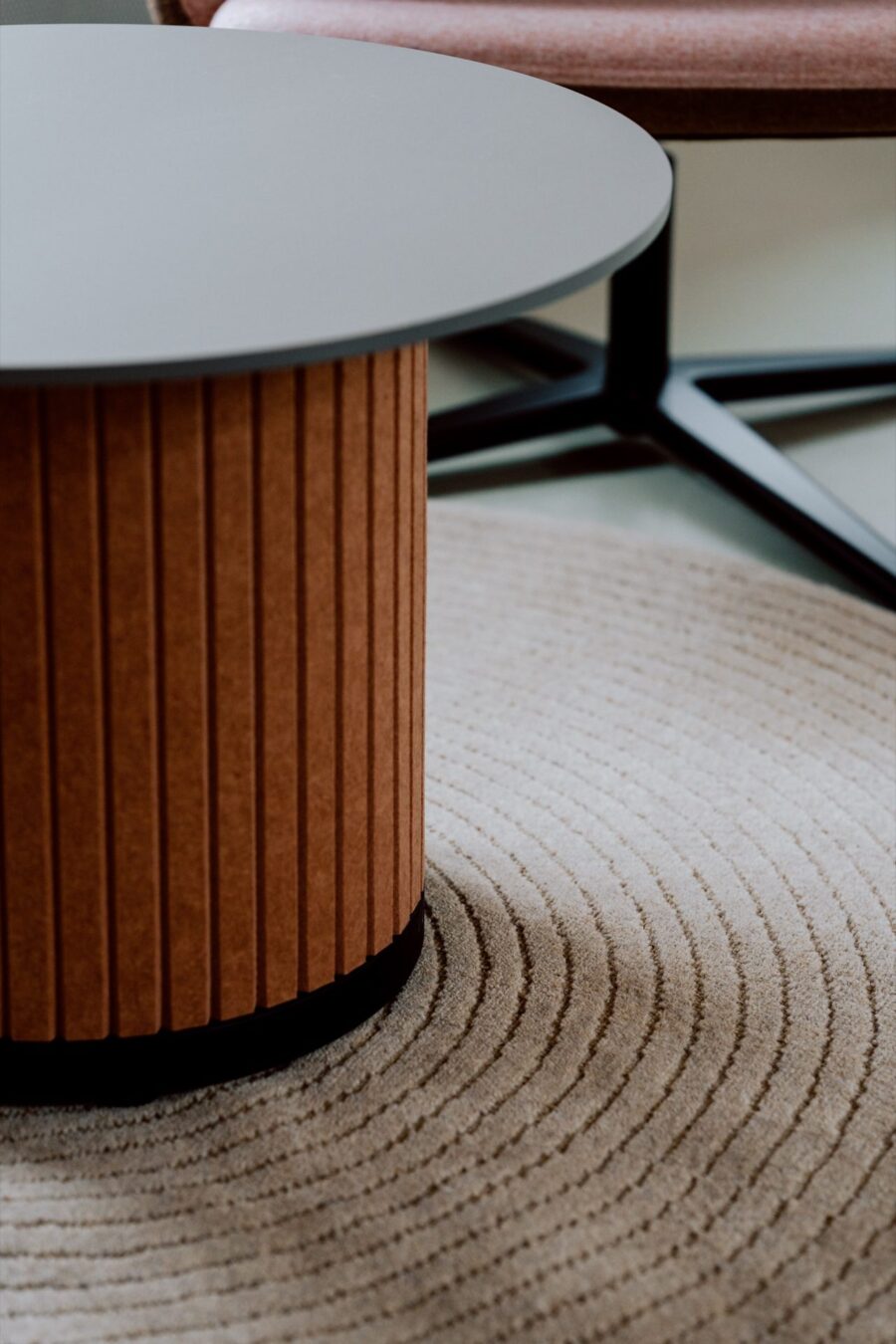 Detail of a fluted Narbutas table base on a woven rug