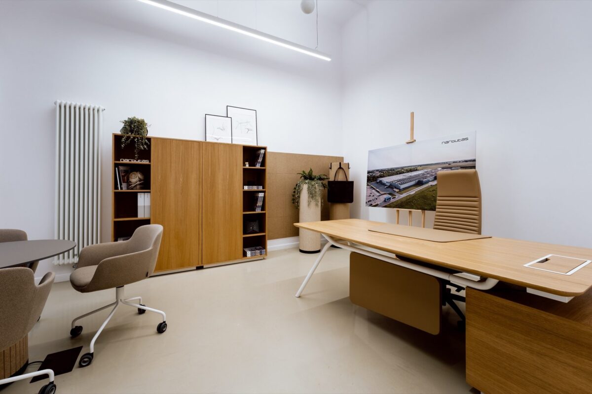Office with a Narbutas desk and a board showing the brand's factory