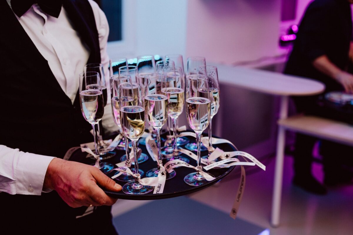 A waiter with a tray of glasses at the Narbutas showroom opening
