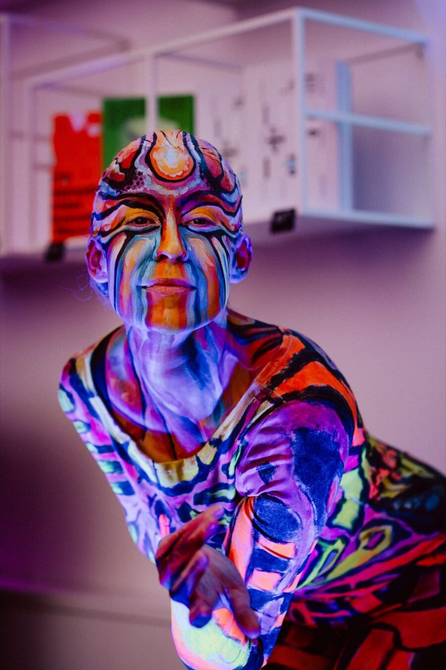 Performer in body paint glowing under ultraviolet light, Narbutas showroom