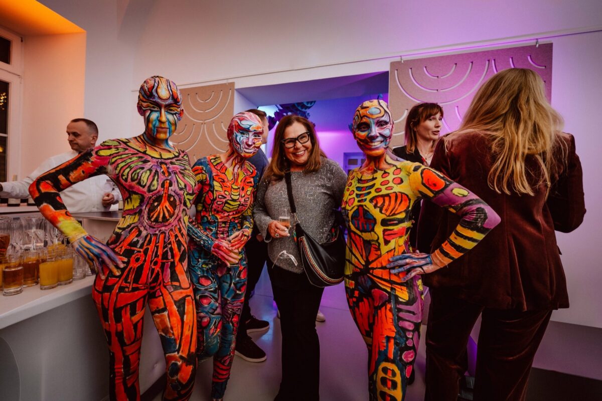 Performers in body paint posing with guests at the Narbutas showroom opening