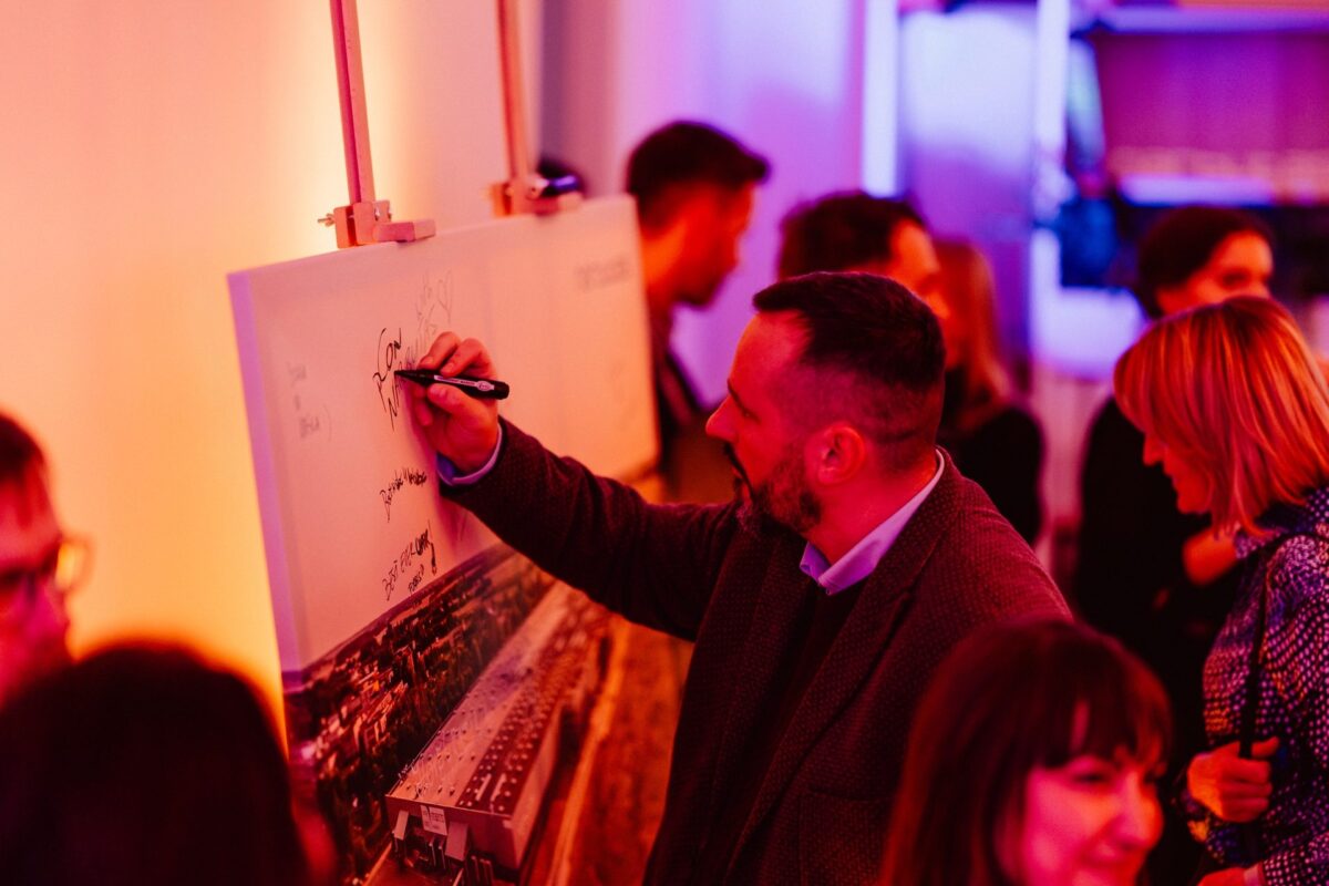 A guest writing a note on the board with a photograph of the Narbutas factory