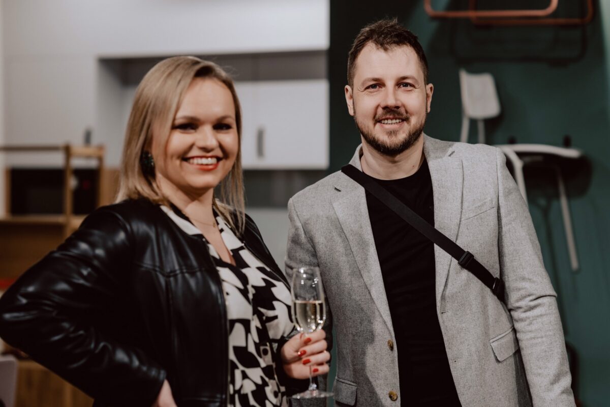 Para gości z kieliszkiem wina na wydarzeniu w showroomie ISKU