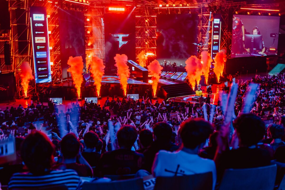 Pirotechnika na scenie i uniesione ręce kibiców na pierwszym planie, IEM Katowice 2024