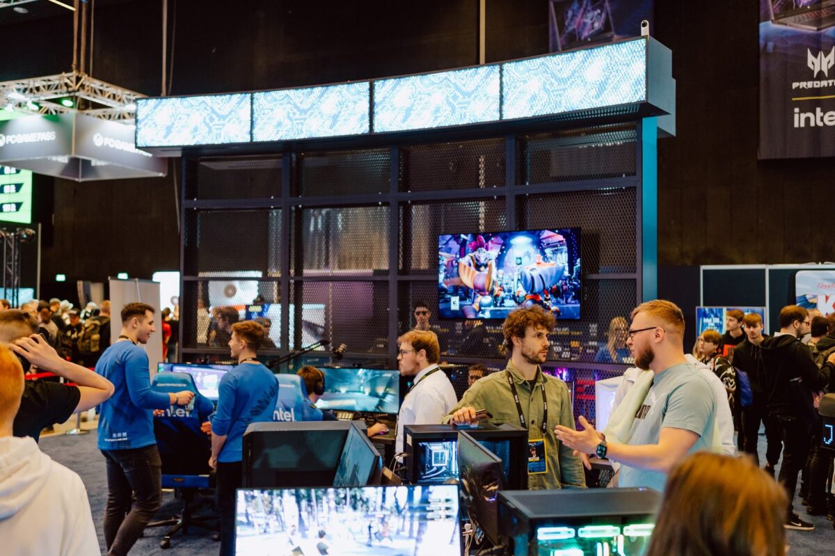 Stoisko Intel z ekranami, stanowiskami do gry i ruchem zwiedzających, IEM Katowice 2024