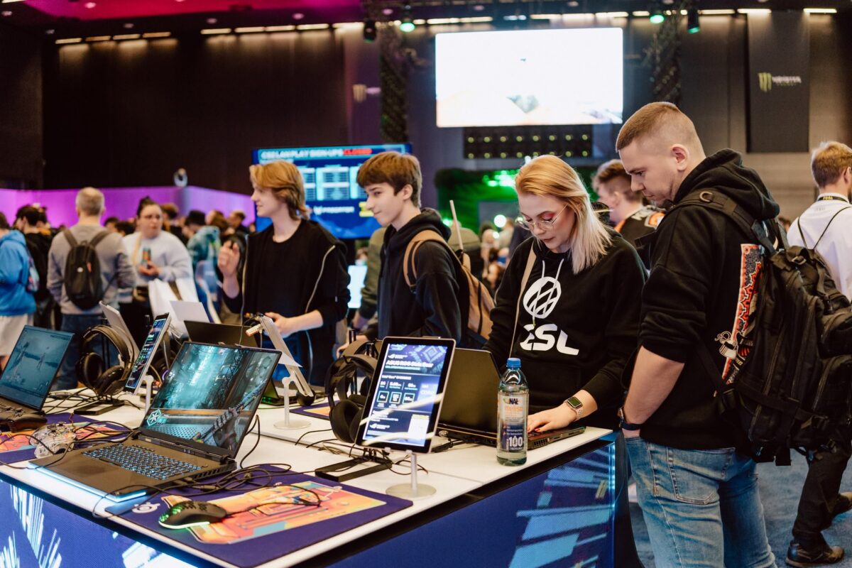 Zwiedzający testują laptopy gamingowe na stoisku w hali Expo, IEM Katowice 2024