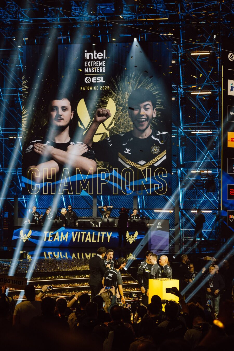 Ekran z napisem Champions nad świętującymi mistrzami na scenie IEM Katowice 2025