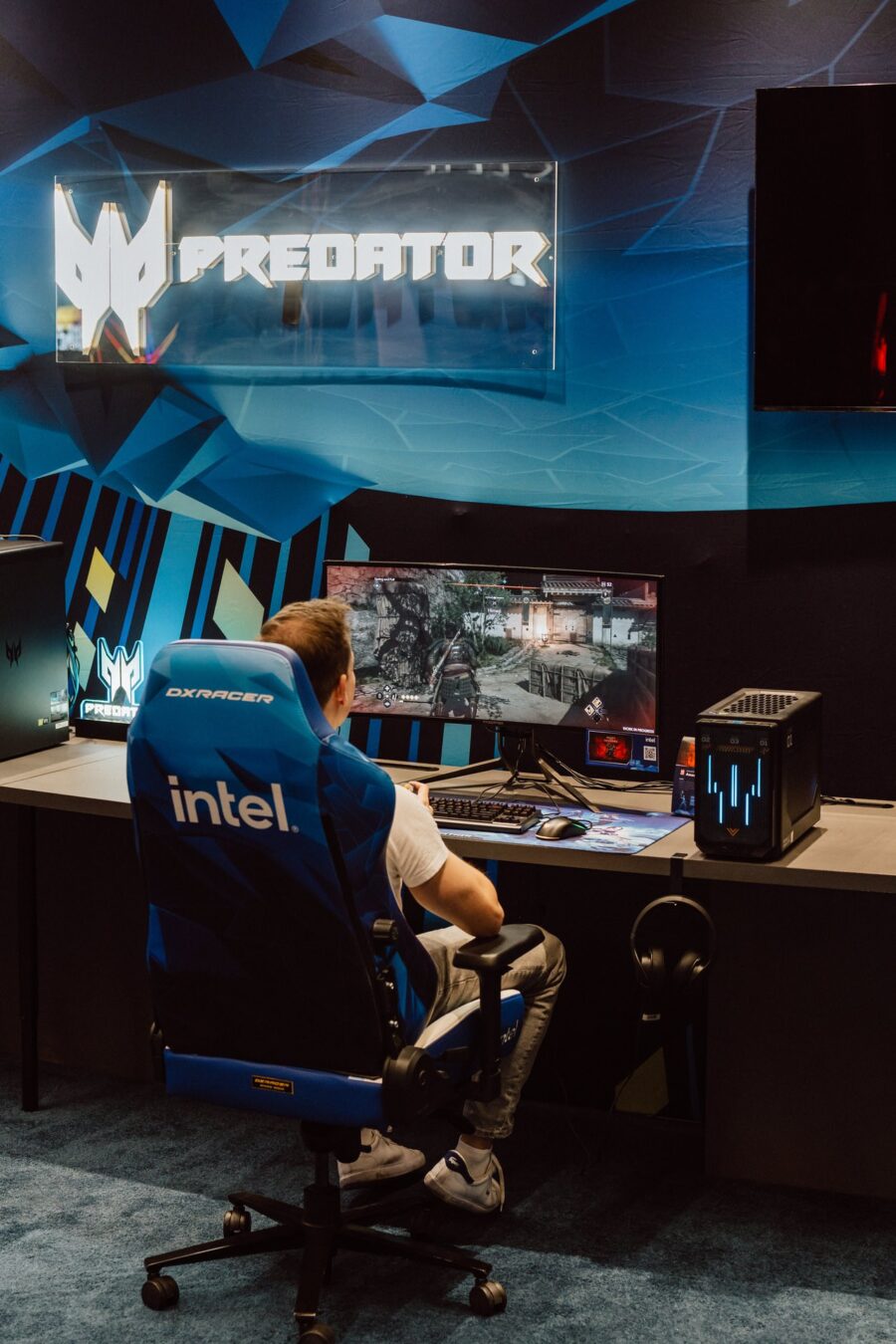 Gracz przy stanowisku pod neonem Predator na stoisku Acer podczas IEM Katowice 2025