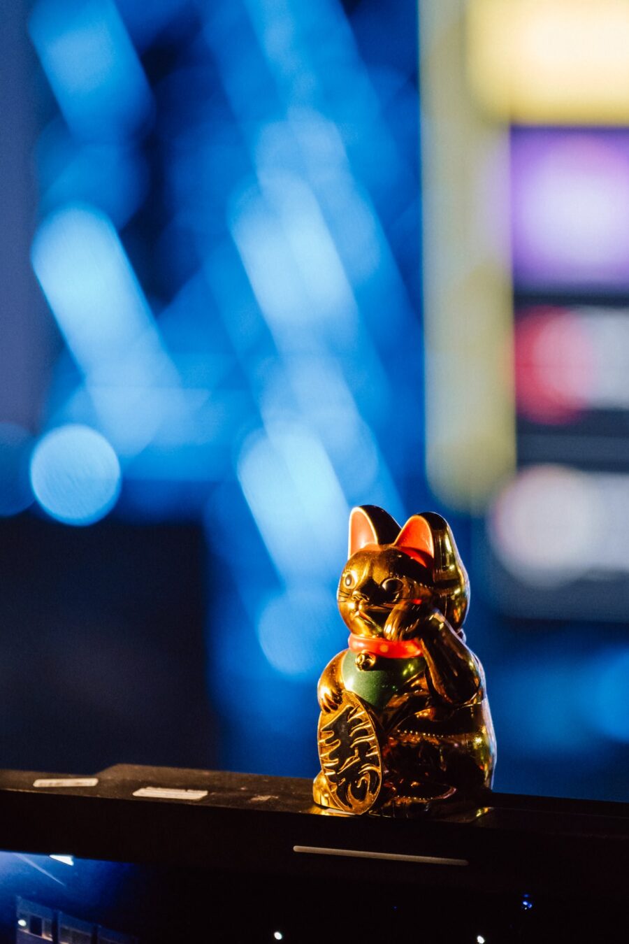 Złoty kot maneki-neko na tle świateł sceny w Spodku, IEM Katowice 2025